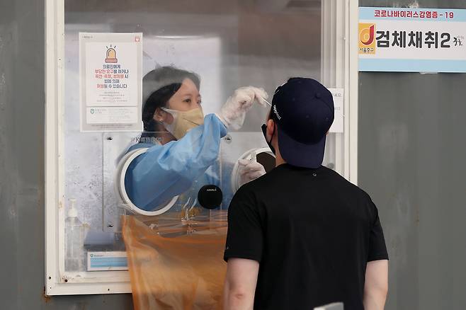 지난달 25일 오후 서울 중구 서울역 광장에 마련된 코로나19 선별검사소에서 한 시민이 검체를 채취하고 있다. /뉴스1