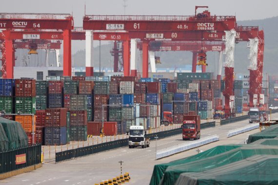 세계무역기구(WTO)가 5일(현지시간) 내년 세계 교역 성장률 전망치를 3.4%에서 1%로 급격히 하향조정했다. 지난해 4얼 28일 중국 산둥성 칭다오 항 터미널에서 트럭들이 컨테이너들을 나르고 있다. 로이터뉴스1