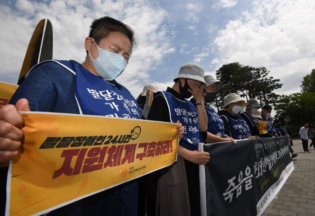 전국장애인부모연대 회원들이 지난 5월 26일 서울 용산구 전쟁기념관 6.25 상징탑 앞에서 죽음을 강요당한 발달장애인과 그 가족에 대한 추모제를 진행하는 중 고인들에 대한 묵념을 하고 있다. 홍인기 기자