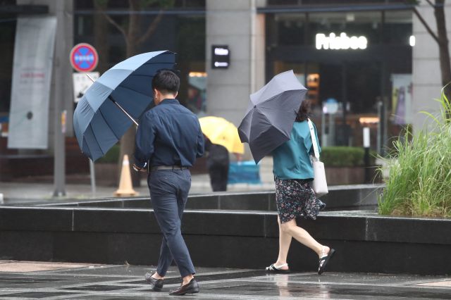 서울 청계광장에서 우산으로 비바람을 막으며 걸어가고 있는 시민들 모습. 연합뉴스
