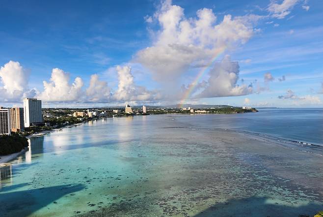 아침에 호텔 객실에서 바라본 투몬만에 무지개가 걸려 있다. [사진/진성철 기자]