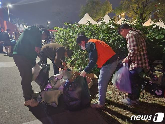 8일 오후 서울세계불꽃축제가 끝난 후 시민들이 서울 영등포구 여의도한강공원에서 자원봉사자들이 쓰레기를 치우고 있다. ⓒ 뉴스1