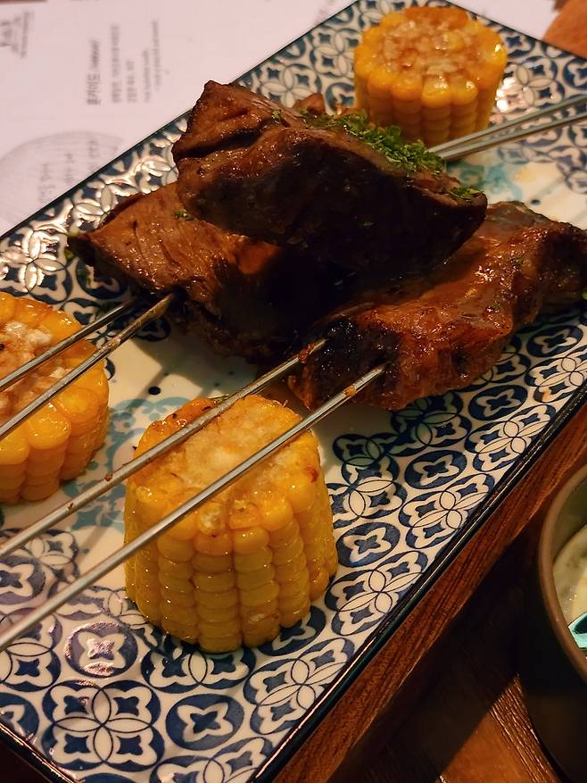 Brazilian-style marinated beef is served with grilled corn and a spicy dip at a stop for Rio de Janeiro during a show “The Grand Expedition." (Hwang Dong-hee/The Korea Herald)