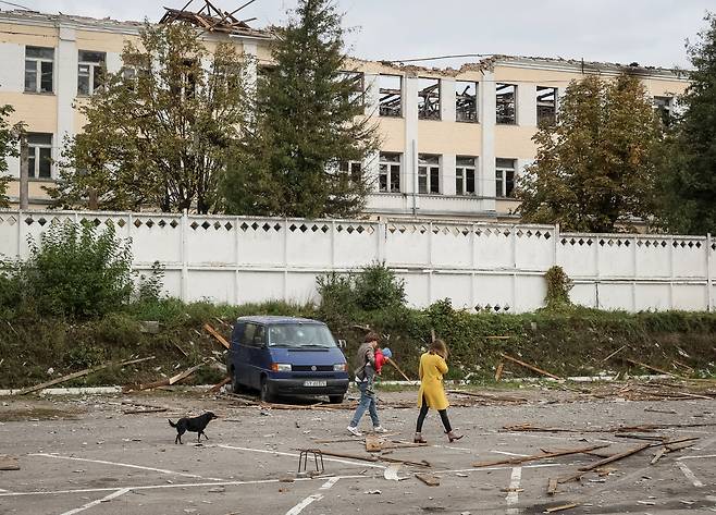 러시아군의 이란제 자폭 드론 공격으로 파괴된 우크라이나 키이우주 빌라체르크바의 건물 인근으로 주민들이 걸어가고 있다. /연합뉴스