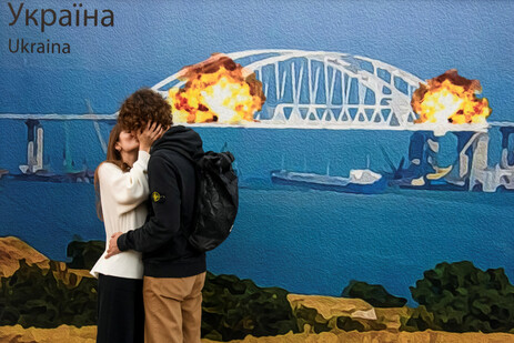 남녀 한 쌍이 8일(현지시각) 우크라이나 키이우에서 ‘케르치 다리’(Kerch bridge)가 폭발하는 장면을 형상화한 대형 시각물 앞에서 키스하고 있다. 로이터 연합뉴스