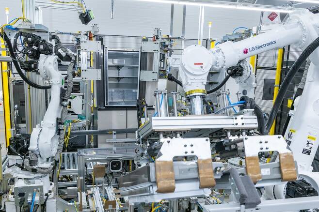 LG스마트파크에 설치된 로봇 팔이 20kg이 넘는 냉장고 문을 본체에 조립하고 있다(LG전자 제공).