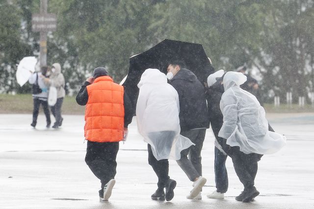 서울 반포 한강공원에서 10일 오후 시민들이 우산과 우의로 비바람을 막고 있다. 연합뉴스