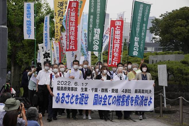 [도쿄=AP/뉴시스] 17일 일본 도쿄의 최고재판소(대법원) 앞에서 후쿠시마 제1 원전 사고 피해 주민과 이들의 지지자들이 정부의 배상을 촉구하며 시위하고 있다. 일본 최고재판소는 이날 후쿠시마 제1 원전 폭발 사고에 대해 국가의 배상 책임이 없다고 판결했다. 2022.06.17.