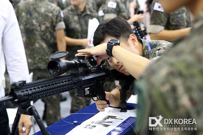 방산 전시회에 전시된 국산 총기를 다뤄보는 육군 간부