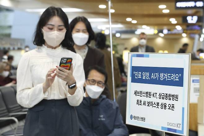 서울 신촌 세브란스병원에서 환자들이 AI 보이스봇의 안내를 받아 진료일정을 확인하고 있다.(사진=KT제공)