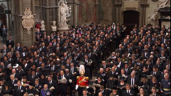지난달 19일 영국 웨스트민스터 사원에서 치러진 엘리자베스 2세 여왕 장례식. 거의 모든 참석자가 마스크를 쓰지 않은 가운데 중국의 왕치산 부주석이 흰 마스크를 착용하고 있었다(중앙에서 약간 왼편의 석상 앞). 중앙포토
