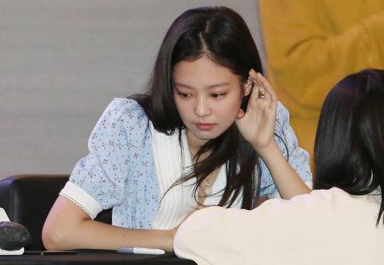 블랙핑크 멤버 제니가 지난달 25일 서울 여의도 IFC몰에서 열린 팬사인회에서 팬의 이야기를 듣고 있다. 사진 뉴스1
