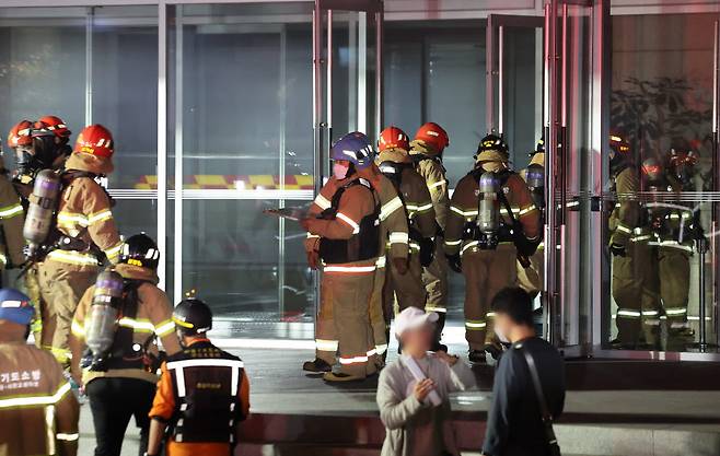 15일 저녁 경기도 성남시 분당구 삼평동 SK 판교 캠퍼스 A동에서 관계자들이 복구작업 투입을 위해 소방관들과 함께 분주하게 움직이고 있다.<연합뉴스>
