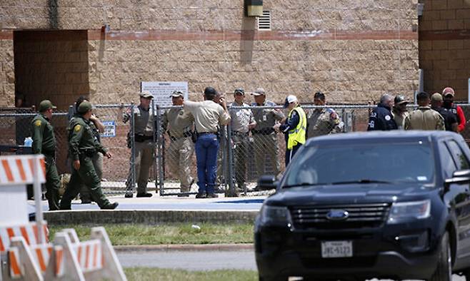 지난 5월 24일(현지시간) 무차별 총기 난사 사건이 발생한 미국 텍사스주 소도시 유밸디의 롭 초등학교 밖에 출동한 경찰과 구급대원들이 모여 있다. AP연합뉴스