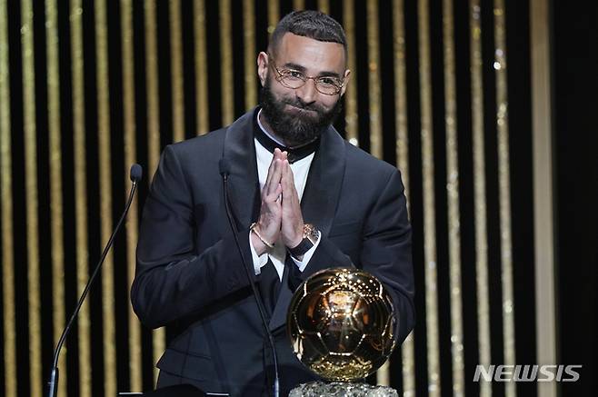 [파리=AP/뉴시스] 카림 벤제마(레알 마드리드)가 17일(현지시간) 프랑스 파리의 샤텔레 극장에서 열린 제66회 발롱도르 시상식에서 남자 발롱도르 트로피를 받고 기뻐하고 있다. 벤제마는 지난 시즌 라리가 32경기 27골 12도움으로 리그 득점왕, 챔피언스리그에서도 12경기 15골로 득점왕을 차지했다. 2022.10.18.