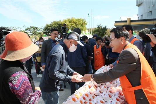 김하수 청도군수(사진 오른쪽)가 10월14일 청도반시축제장을 방문한 관람객들에게 청도반시를 나눠주며 홍보하고 있다. ⓒ청도군
