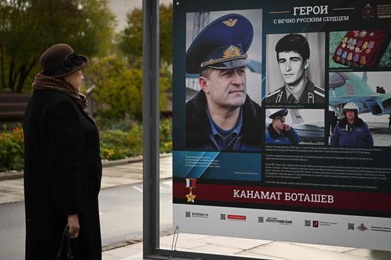 현지시간 19일 한 여성이 모스크바 한 공원에서 러시아 군인들을 기리는 포스터를 보고 있다. 〈사진=AFP 연합뉴스〉