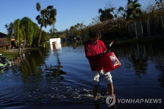 물에 잠긴 거리를 한 플로리다 주민이 가로지르고 있다. 
사진=AP 연합뉴스