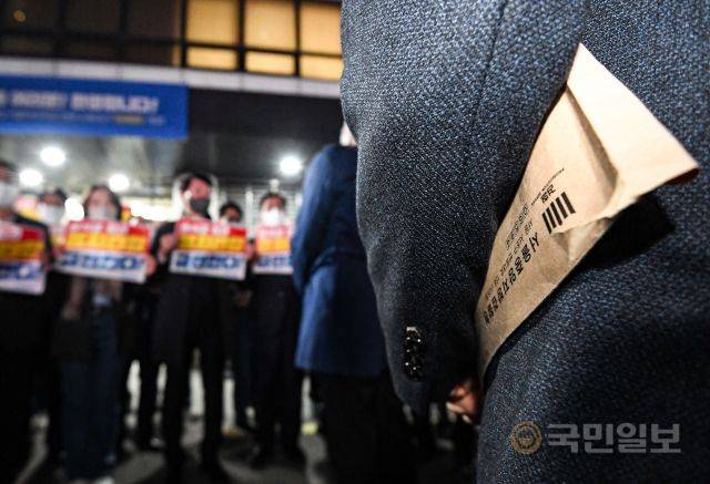 19일 서울 여의도 중앙당사 앞에서 민주연구원 압수수색에 나선 한 검찰 관계자가 '서울중앙지방검찰청'이 적힌 서류 봉투를 들고 있다.