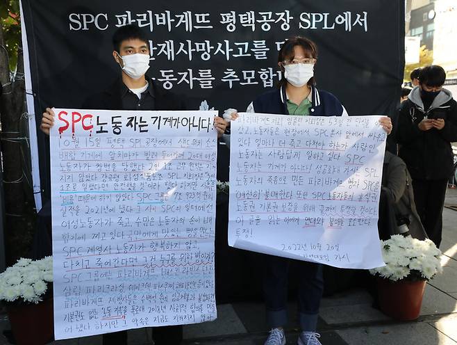 20일 오후 서울 양재동 SPC 본사 앞에서 열린 SPC 계열사 SPL 평택 제빵공장 사망 사고 희생자 서울 추모행사에서 대학생 단체가 SPC를 규탄하는 대자보를 취재진들에게 보여주고 있다. 뉴시스