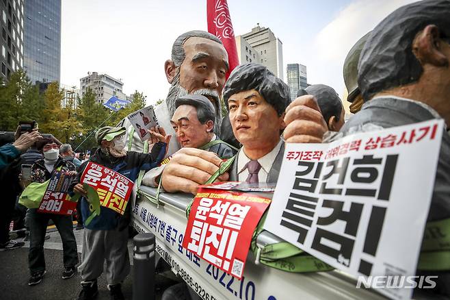 [서울=뉴시스] 정병혁 기자 = 22일 서울 중구 태평로에서 열린 촛불행동 김건희 특검 윤석열 퇴진 11차 전국집중 촛불대행진에서 참가자들이 집회장소에 설치된 윤석열 대통령 조각상 앞에서 사진을 찍고 있다. 2022.10.22. jhope@newsis.com