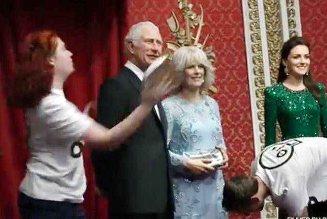 저스트 스톱 오일 소속 회원들이 24일 세계적 밀랍인형 전시관인 마담투소 런던지사에서 찰스 3세 국왕의 밀랍인형 얼굴에 케이크를 투척하고 있다. 트위터 캡처