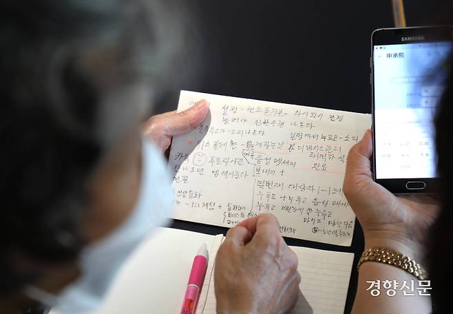 지난 9월2일 서울 성북구의 한 카페에서 ‘스마트폰 선생님’을 만난 한 어르신이 암호처럼 빼곡하게 적은 메모를 보며 지난 수업에서 배운 메신저로 음성을 보내는 방법을 복습하고 있다. 강윤중 기자