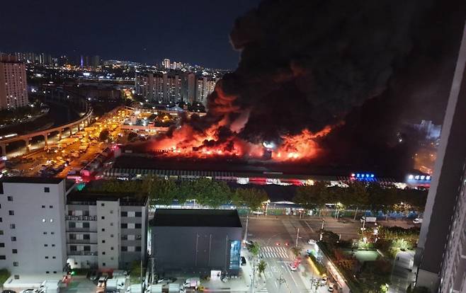 25일 밤 대구 북구 매천동 농수산물도매시장에서 대형 화재가 발생해 불길과 함께 검은 연기가 치솟고 있다. 소방당국은 대응 2단계를 발령하고 화재 진압 작업을 벌였다. 연합뉴스