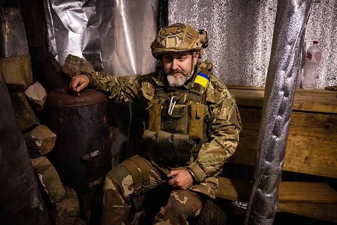 우크라이나 군인인 24일(현지시간) 동부 도네츠크 참호 안에 겨울철에 대비해 만든 사우나 시설 앞에 앉아 있다. [AFP]
