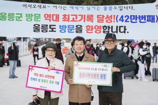 남한권 울릉군수(중간)와 42만번째 입도 주인공이 기념사진을 촬영하고 있다.