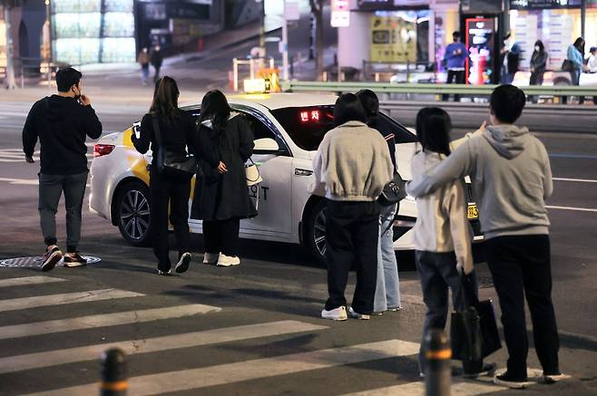 People are trying to grab a taxi at night in an area nearby Gangnam Station, Seoul. (Yonhap)