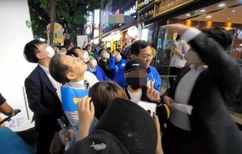 지난 5월 20일 이재명 당시 인천 계양을 국회의원 후보가 거리 유세 중 철제그릇이 떨어지자 쳐다보고 있다 (사진=유튜브 채널 ‘이재명’ 영상 캡처)