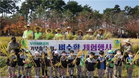 이해성 이사장(가운데) 등이 벼 수확 행사에 참여한 어린이들과 함께 기념촬영을 하고 있다./제공=부산시설공단