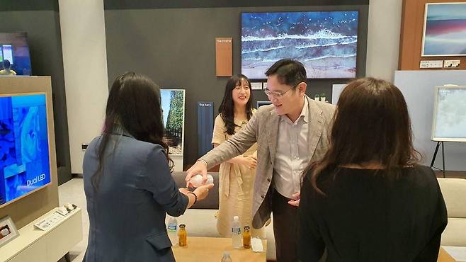 이재용 삼성전자 회장이 2020년 8월 삼성전자 수원사업장에서 워킹맘인 여성 임직원들과 간담회를 갖기 전 손소독제를 뿌려주고 있다./삼성전자 제공