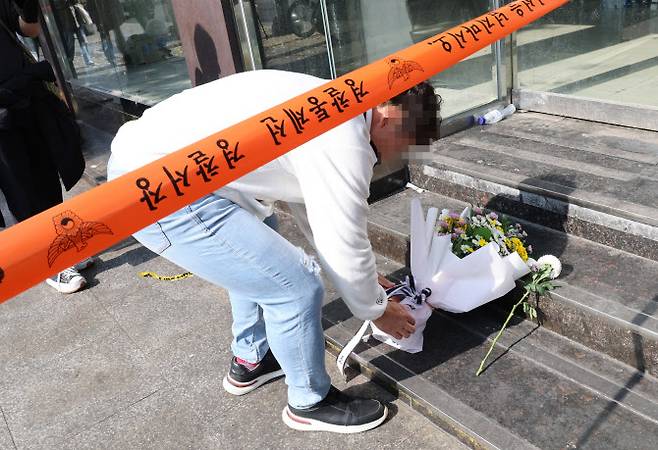 30일 한 시민이 ‘이태원 참사’ 현장에 추모 꽃다발을 놓고 있다. (사진=연합뉴스)