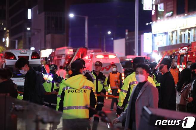 30일 새벽 서울 용산구 이태원 거리에서 경찰과 소방대원들이 대규모 압사 사고를 수습하고 있다. 29일 밤 서울 용산구 이태원 한복판에서 심정지 환자가 대규모로 발생했다. 3년 만에 첫 '야외 노마스크' 핼러윈을 맞아 인파가 몰리면서 대규모 압사사고가 일어난 것으로 추정된다. 소방청은 이날 오후 11시13분 이태원에서 압사 추정 사고가 발생함에 따라 대응 3단계로 격상한다고 밝혔다. 2022.10.30/뉴스1 ⓒ News1 장수영 기자