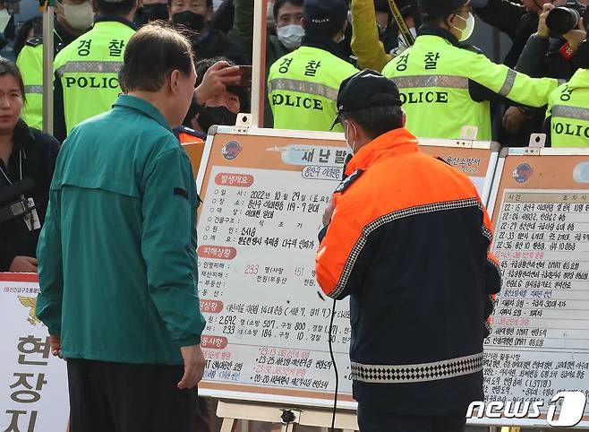 윤석열 대통령이 30일 오전 서울 용산구 이태원 핼러윈 압사사고 현장을 찾아 소방과 경찰의 설명을 듣고 있다. 윤 대통령은 이날 대국민 담화를 통해 "오늘부터 사고 수습이 일단락될 때까지 국가애도기간으로 정하고 국정의 최우선순위를 본 건 사고의 수습과 후속조치에 두겠다＂고 말했다. 2022.10.30/뉴스1 ⓒ News1 임세영 기자