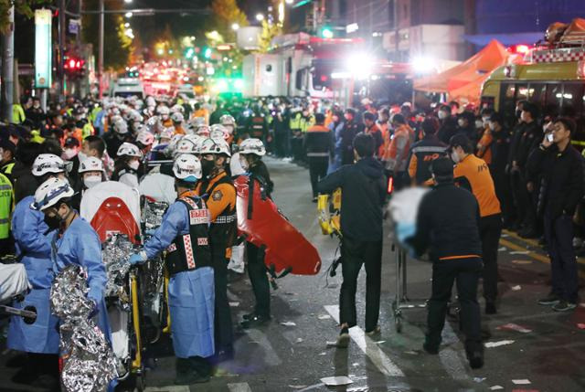 지난 29일 밤 서울 용산구 이태원 일대에서 대규모 압사 사고가 발생해 30일 새벽 소방구급 대원들이 환자를 이송하고 있다. 뉴시스