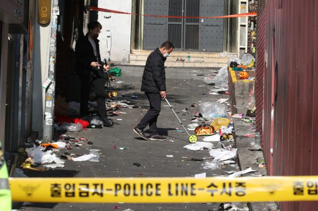 30일 오전 서울 용산구 이태원 압사사고 현장에서 경찰 관계자들이 사고 현장 골목 폭을 측정하고 있다. 이태원 압사사고로 발생한 인명피해는 이날 현재 사망 151명, 중상 19명, 경상 63명이다. 뉴스1