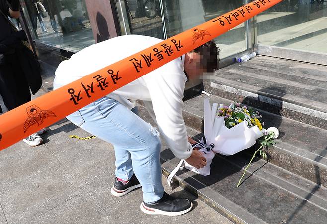 30일 한 시민이 이태원 압사 사고 현장에 추모 꽃다발을 놓고 있다. 연합뉴스