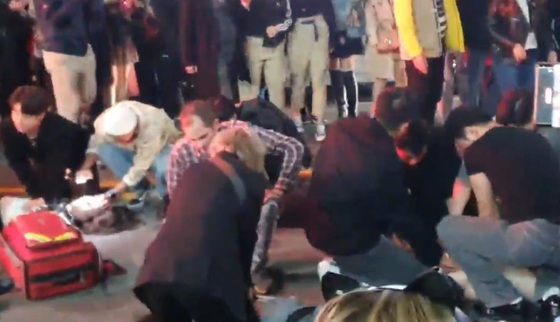 Private citizens perform CPR on people who collapsed in the crowds in Itaewon on Saturday. [YONHAP]