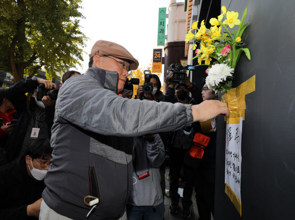 30일 오후 서울 용산구 이태원 할로윈 참사 현장 인근 건물 외벽에 한 시민이 근조화를 부착하고 애도하고 있다. 2022.10.25 뉴시스