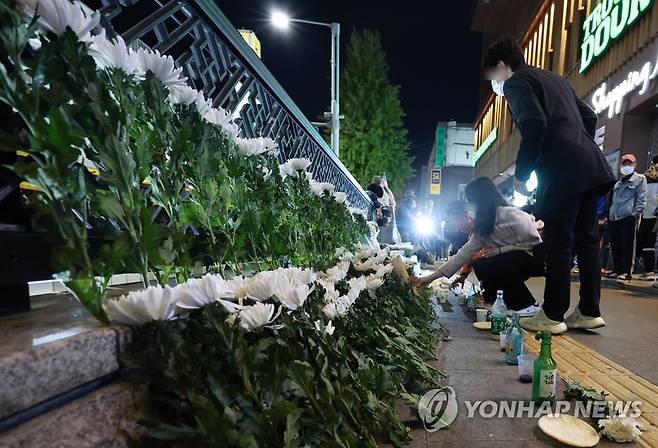 참사 하루, 계속되는 헌화와 추모 (서울=연합뉴스) 홍해인 기자 = 30일 오후 서울 용산구 지하철 6호선 이태원역 1번 출구 앞에 마련된 '핼러윈 인파' 압사 사고 희생자 추모 공간에서 시민들이 헌화하고 있다. 2022.10.30 hihong@yna.co.kr