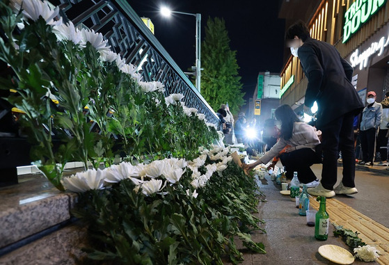 서울 용산구 지하철 6호선 이태원역 1번 출구 앞에 마련된 이태원 참사 희생자 추모 공간에서 시민들이 헌화하고 있다. 〈사진=연합뉴스〉