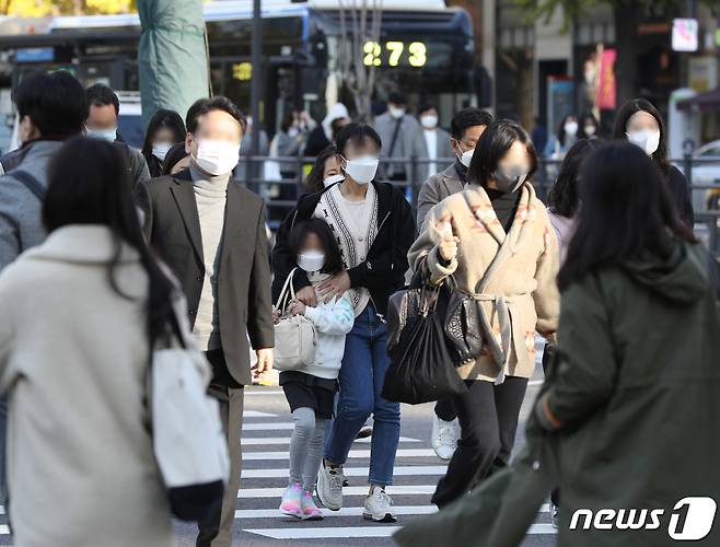 반짝 추위가 찾아왔던 10월24일 오전 서울 광화문네거리에서 한 어린이가 엄마 품에 안겨 횡단보도를 걷고 있다. 기상청은 내일 서울 최저기온이 5도까지 떨어지며 추위가 이어지다가 오는 26일 낮부터 풀릴 것으로 예보했다. 2022.10.24/뉴스1 ⓒ News1 신웅수 기자