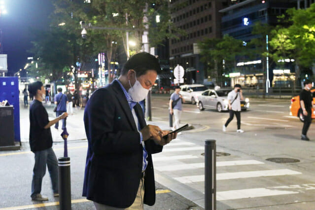 원희룡 국토교통부 장관이 자정 무렵 서울 강남역 사거리에서 휴대폰 앱으로 택시를 호출하고 있다.