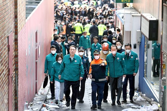 윤석열 대통령이 30일 오전 이태원 참사 현장을 찾아 소방 관계자의 설명을 들으며 다수의 사상자가 발생한 골목길을 살펴보고 있다. [사진 대통령실]