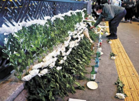 30일 저녁 서울 용산구 이태원 참사 사고 인근에 마련된 추모공간에서 시민들이 조화를 내려놓고 있다.뉴스1