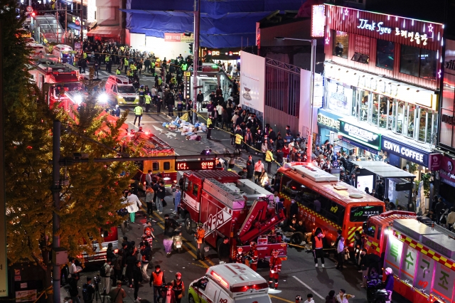 30일 새벽 서울 용산구 이태원 참사 현장에 출동한 119 구조대원들이 희생자들을 구조하고 있다. 연합뉴스