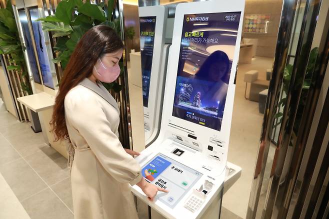 NH투자증권이 강남금융센터에 STM 기기를 설치했다. 사진은 한 고객이 STM 기기를 사용하고 있는 모습이다./사진=NH투자증권